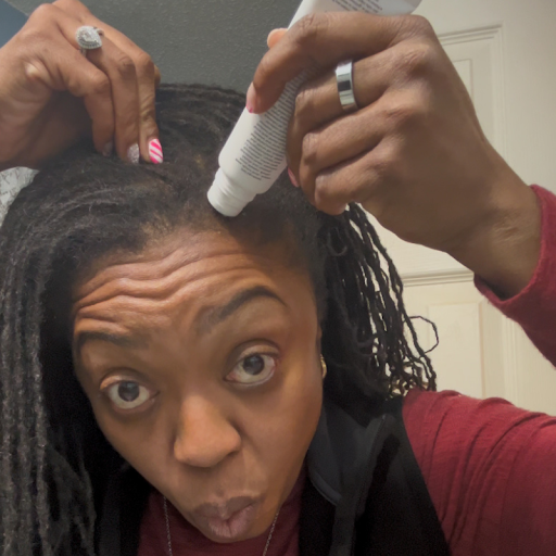 Applying the ampoule directly to the scalp along the part